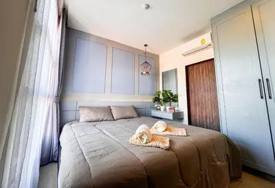 a dog laying on a bed in a bedroom at Cozy 1BR Apartment with Big Balcony - 2 Pools & 5 mins from Surin Beach in Phuket Town