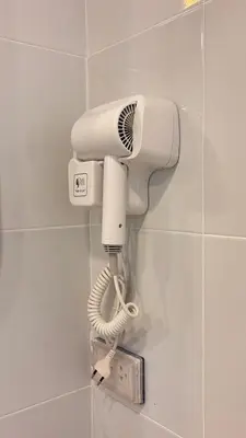 a hairdryer on a wall in a bathroom at Brightstar Hostel in Phi Phi Don