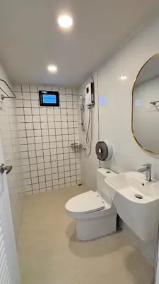 a bathroom with a toilet and a sink and a mirror at Brightstar Hostel in Phi Phi Don