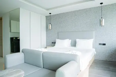 a bedroom with a white bed and a couch at Karen Sunset Hotel in Phuket Town