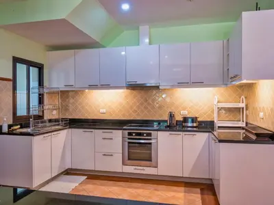 a large kitchen with white cabinets and appliances at Happy villa in Laguna in Layan Beach