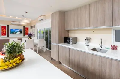 a kitchen with a bowl of fruit on a counter at The Sense Villa Phuket in Rawai Beach