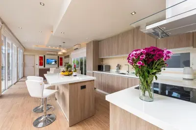 a kitchen with a vase of flowers on a counter at The Sense Villa Phuket in Rawai Beach