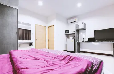 a bedroom with a bed with a pink blanket at Ra Residence Phuket in Chalong