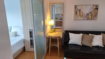 a living room with a black couch and a table at Plus condo 2 kathu by Tida in Kathu