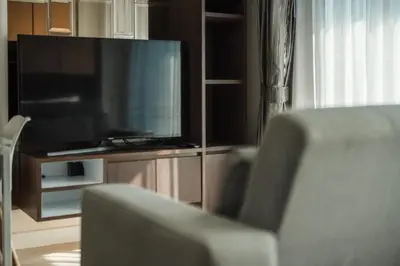 a living room with a flat screen tv and a chair at C153 The Aristo Luxury Beach Resort Phuket in Thalang