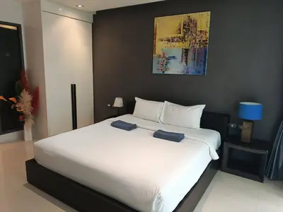 a large white bed with two blue towels on it at Emerald Terrace Serenity 11 - 5th Floor Garden View by PSR in Patong Beach