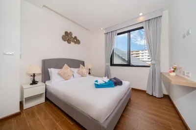 a bedroom with a white bed and a window at Goldena Twin Private Pool Villas in Kamala Beach