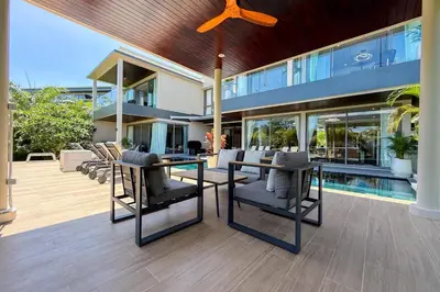 a house with a patio with a table and chairs at Villa Lion Phuket in Phuket