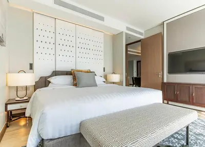 a bedroom with a large white bed and a flat screen tv at Infinite Ocean Retreats at Angsana Oceanview in Laguna Phuket