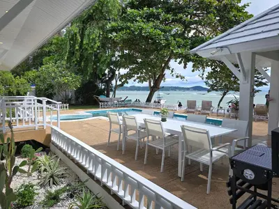 a patio with a table and chairs next to a pool at Seaside Bliss Beach Villa Rawai in Rawai Beach