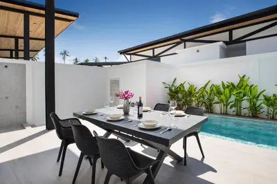 an outdoor dining area with a table and chairs and a swimming pool at New, Modern & Stylish 17m Eco Pool Villa Sunset Garden 11 in Rawai in Rawai Beach