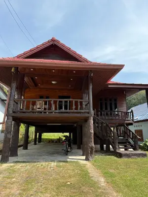 a large wooden house with a porch and a balcony at Chaba House Koh Yao Noi in Ban Laem Sai