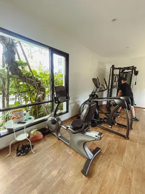 a gym with two exercise bikes and a person in a mirror at Cozy Paradise By Rawai Beach in Phuket Town