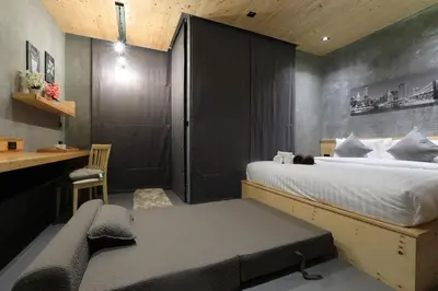 a bedroom with a bed and a desk and a chair at ReLife The Windy Naiharn in Rawai Beach