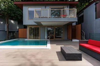 a house with a swimming pool and a red couch at Centara Villas Phi Phi Island in Phi Phi Don
