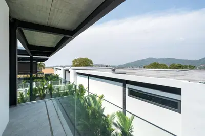a view from the balcony of a building with palm trees at New & Modern, Loft Style 4BR Villa Sunset Garden 3, 12m Salt Pool, just 10min drive Naiharn Beach in Rawai Beach