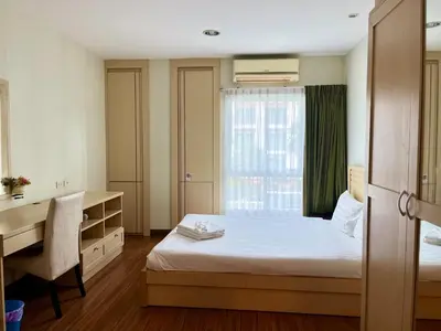 a bedroom with a bed and a desk and a window at Luxury Villa Patong in Patong Beach