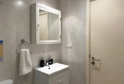 a white bathroom with a sink and a mirror at The Title Residences Apartment 7 min walk to Nai Yang Beach in Nai Yang Beach