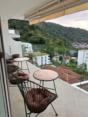 a balcony with two tables and a view of a city at Ocean View Residences! in Phuket Town