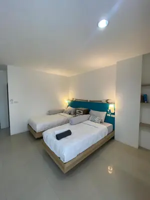 two beds sitting in a room with two lamps at Five Loaves Beds Patong in Patong Beach