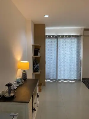 a room with a table with a lamp and a window at Five Loaves Beds Patong in Patong Beach