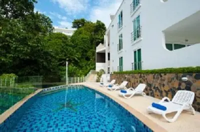 a swimming pool with lounge chairs and a building at Ocean View Residences! in Karon Beach
