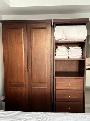 a closet with wooden cabinets and a bed at Ocean View Residences! in Karon Beach
