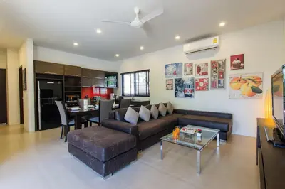 a living room with a couch and a table at Вилла Boutique Pool Villa с 3 спальнями in Ban Saiyuan (1)