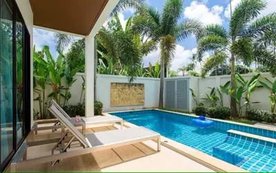 a swimming pool next to a villa with palm trees at Вилла Boutique Pool Villa с 3 спальнями in Ban Saiyuan (1)