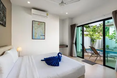 a bedroom with a large white bed and a pool at West facing 3br Boutique Pool Villa in Phuket Town