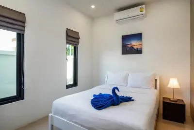 a bedroom with a white bed with a blue ribbon on it at West facing 3br Boutique Pool Villa in Phuket Town