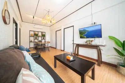 a living room with a couch and a table at Rawai Cottage House in Rawai Beach