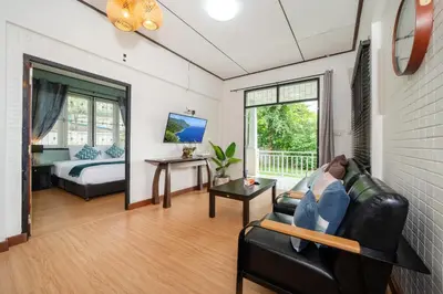 a living room with a couch and a bed at Rawai Cottage House in Rawai Beach