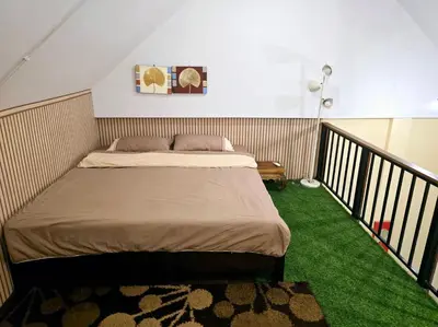 a bed in a room with a green carpet at Baibon 4 Homestay Thalang Phuke in Thalang