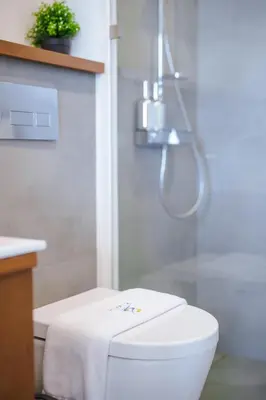 a bathroom with a shower and a toilet with a towel at Lapista 6 Bedroom Luxury Vila in Phuket Town