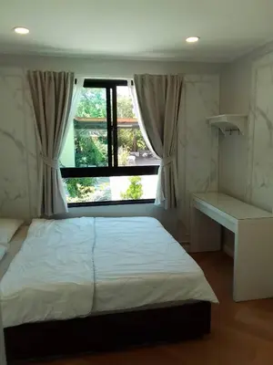a bedroom with a large bed and a window at Little Sweet Home in Phuket Town