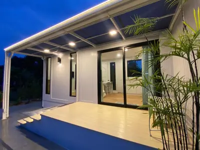 a house with a large deck with glass doors at Little Sweet Home in Phuket Town