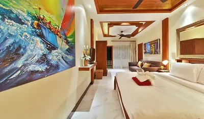 a bedroom with a large painting on the wall at Baan Sung Apartments in Kamala Beach