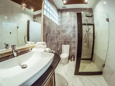 a bathroom with a sink and a shower and a toilet at Baan Sung Apartments in Kamala Beach