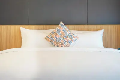 a white bed with two pillows on top of it at Seaside Naithon Phuket - Newly Opened in Nai Thon Beach