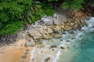 an aerial view of a beach with rocks and water at Seaside Naithon Phuket - Newly Opened in Nai Thon Beach