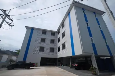 a white and blue building with cars parked in front at Nub-Nueng place นับหนึ่ง เพลส in Ban Bo Han