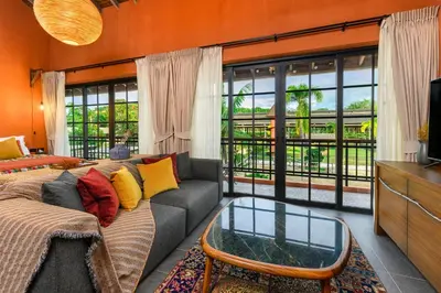 a living room with a couch and a glass coffee table at Niran Farm in Koh Lone