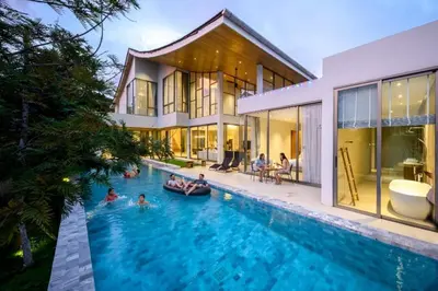 a group of people in the swimming pool of a house at Brand-New & Luxury 5BR Pool Villa Trinity C2 in Bang Tao Beach