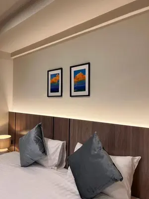 a bedroom with a bed with two pictures on the wall at Karon Boutique in Karon Beach