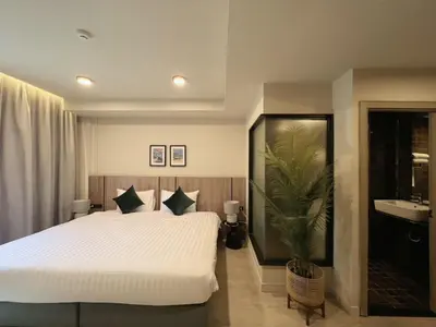 a bedroom with a large white bed and a sink at Karon Boutique in Karon Beach