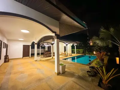 a house with a swimming pool and an arcade at Kesorn Charming Authentic Thai Pool Villa Phuket in Rawai Beach
