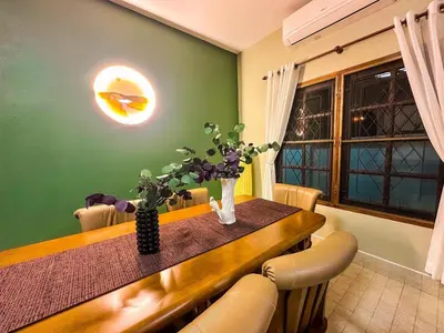 a dining room with a table with chairs and flowers at Kesorn Charming Authentic Thai Pool Villa Phuket in Rawai Beach