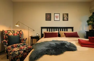 a bedroom with a bed and a chair with a furry pillow at Mountain View Apart Naiyang Beach in Phuket
